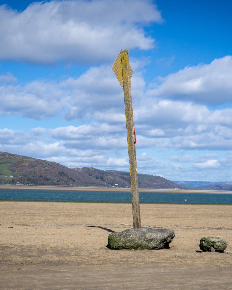 A marker post on the sands of the Dyfi estuary