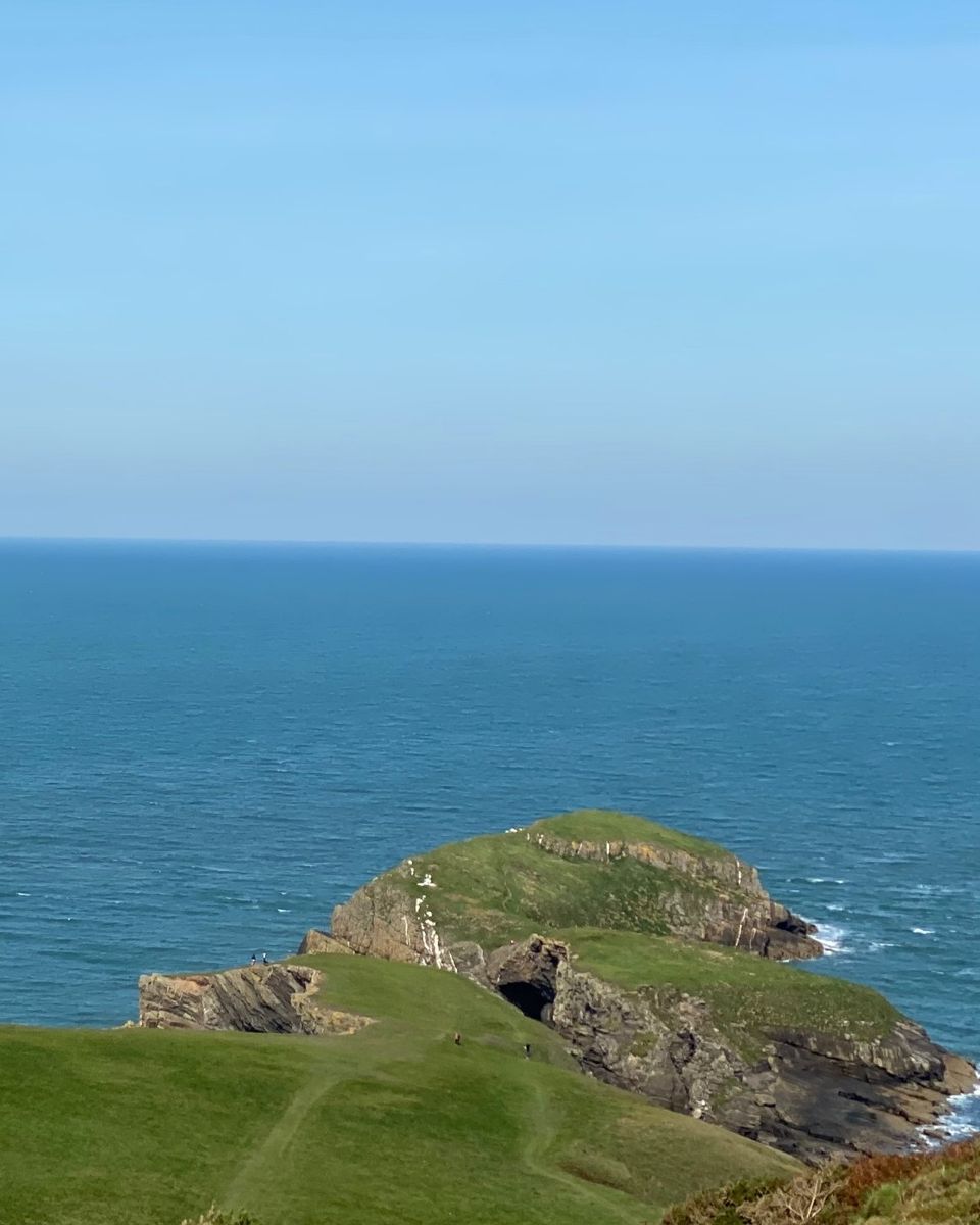 A green headland above a calm sea