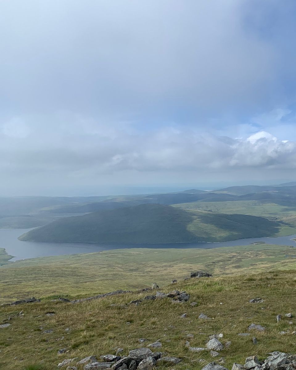 A lake below open hills